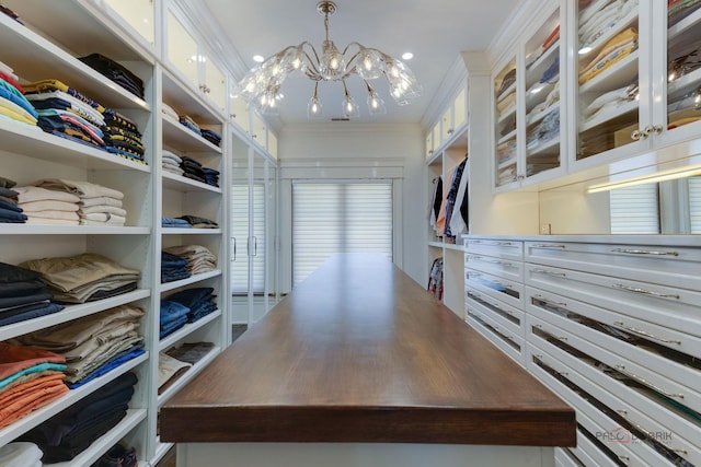 spacious closet with an inviting chandelier