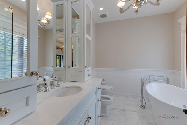 bathroom featuring a bidet, vanity, a bathtub, and toilet