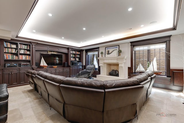 living room with a tray ceiling and a high end fireplace