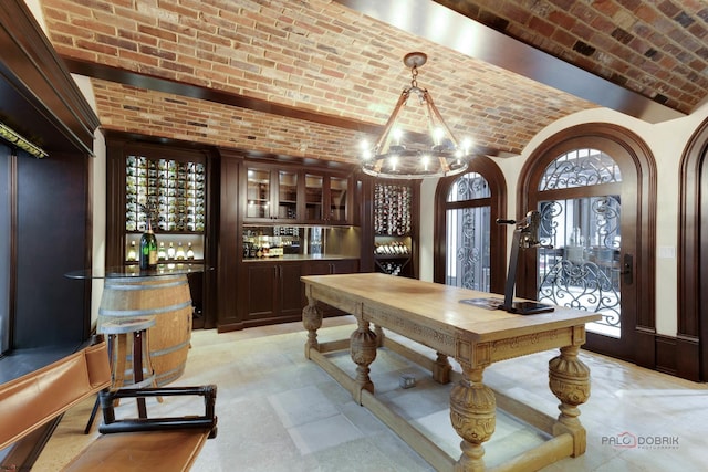 wine cellar featuring an inviting chandelier, brick ceiling, and indoor bar