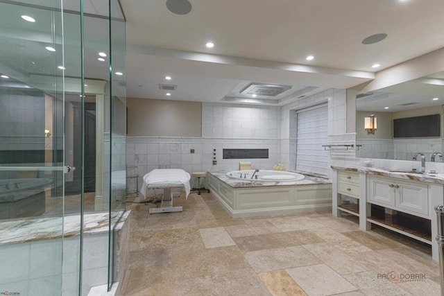 bathroom featuring vanity, plus walk in shower, and tile walls