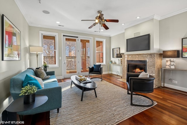 living room with ceiling fan, a high end fireplace, ornamental molding, and hardwood / wood-style floors