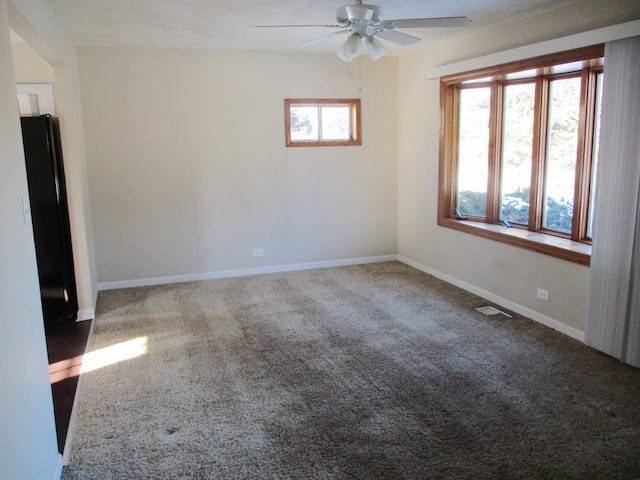 carpeted spare room with ceiling fan