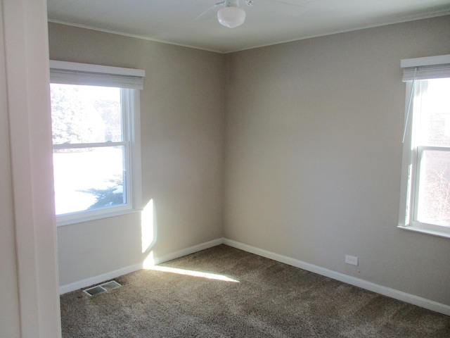 empty room with ceiling fan, a healthy amount of sunlight, and carpet flooring