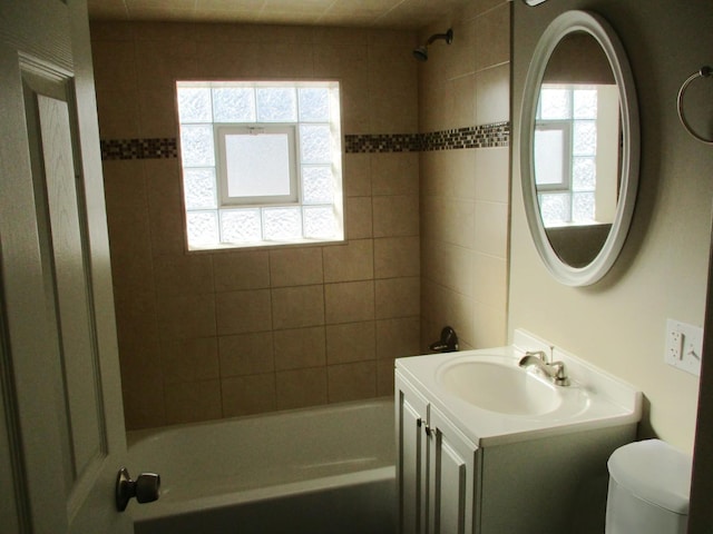 full bathroom with toilet, tiled shower / bath, and vanity