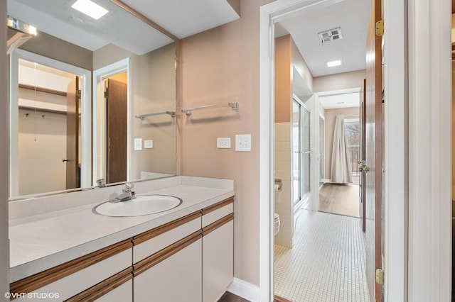 bathroom with vanity, tile patterned flooring, toilet, and walk in shower