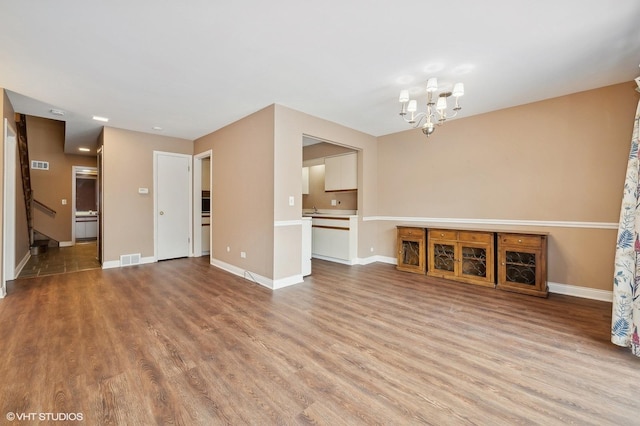 unfurnished living room featuring hardwood / wood-style flooring and a notable chandelier