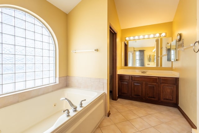 bathroom featuring vanity, tile patterned flooring, vaulted ceiling, and a bathing tub