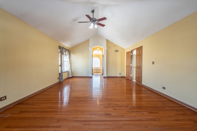 empty room with lofted ceiling, wood-type flooring, ceiling fan, and ornate columns