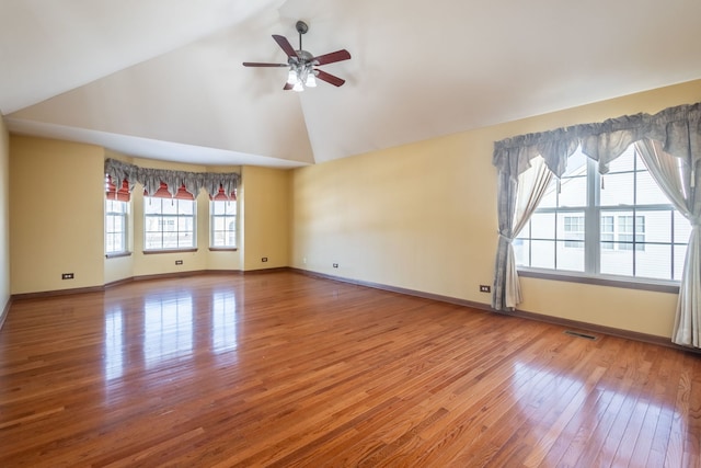 unfurnished room with vaulted ceiling, ceiling fan, plenty of natural light, and hardwood / wood-style floors