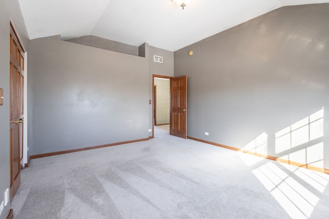 carpeted empty room with lofted ceiling