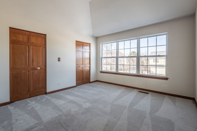 unfurnished bedroom with carpet flooring and high vaulted ceiling