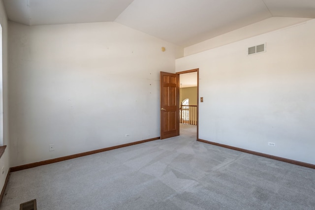 carpeted empty room featuring lofted ceiling