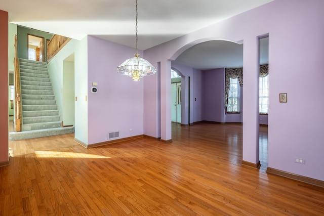 unfurnished dining area with hardwood / wood-style flooring and an inviting chandelier