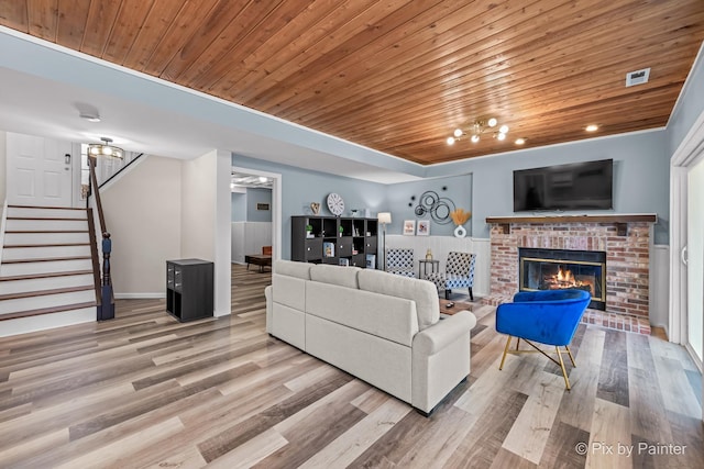 living room featuring wooden ceiling, light wood-type flooring, and a fireplace