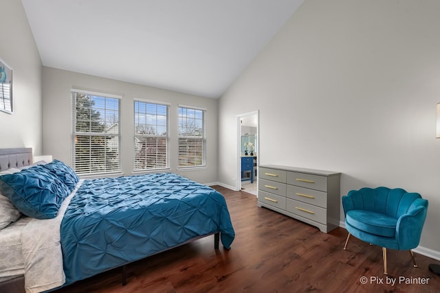 bedroom with ensuite bath, vaulted ceiling, and dark wood-type flooring