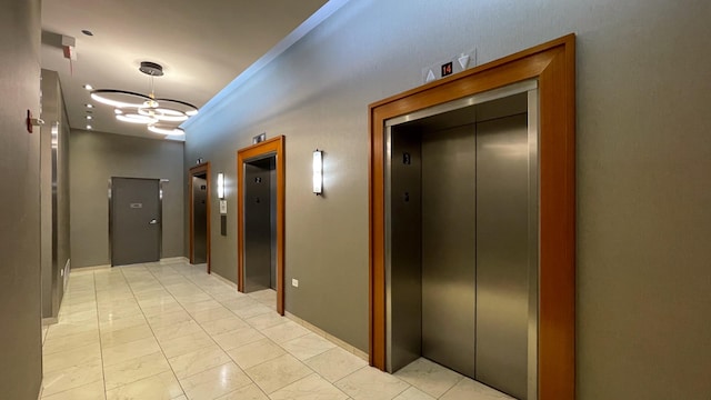 corridor with an inviting chandelier and elevator