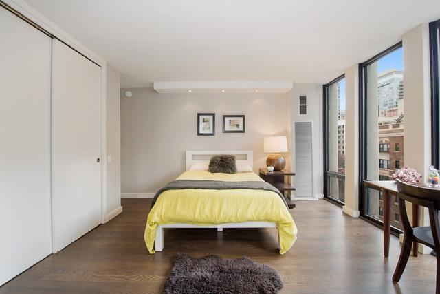 bedroom featuring floor to ceiling windows, wood-type flooring, and a closet