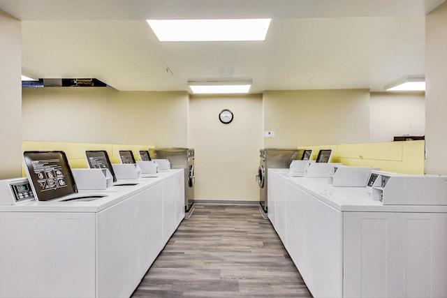 clothes washing area featuring separate washer and dryer and light hardwood / wood-style flooring