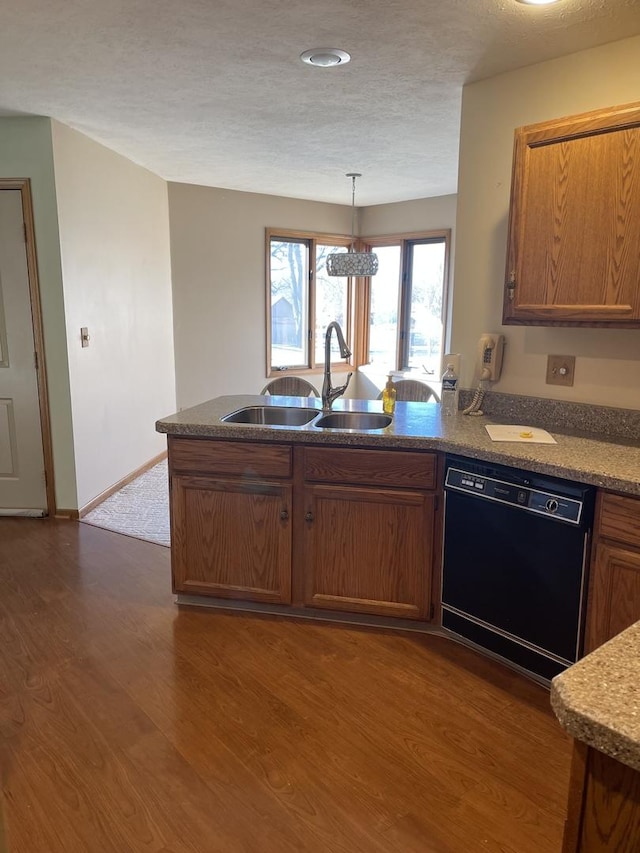 kitchen with black dishwasher, decorative light fixtures, dark hardwood / wood-style flooring, a textured ceiling, and sink