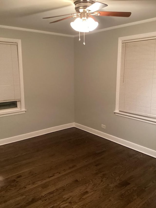 empty room featuring dark hardwood / wood-style flooring, ornamental molding, and ceiling fan