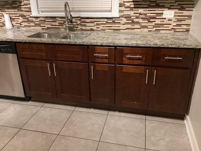 kitchen with dishwasher, light stone countertops, sink, and dark brown cabinetry