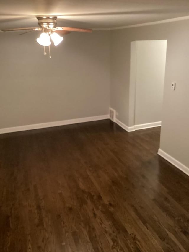 empty room with ceiling fan and dark hardwood / wood-style floors