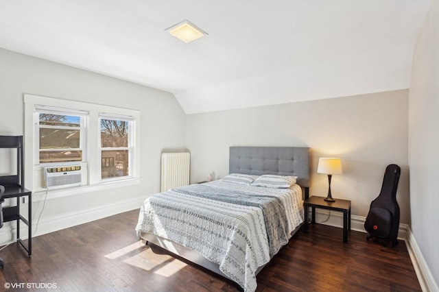 bedroom with vaulted ceiling, cooling unit, hardwood / wood-style flooring, and radiator