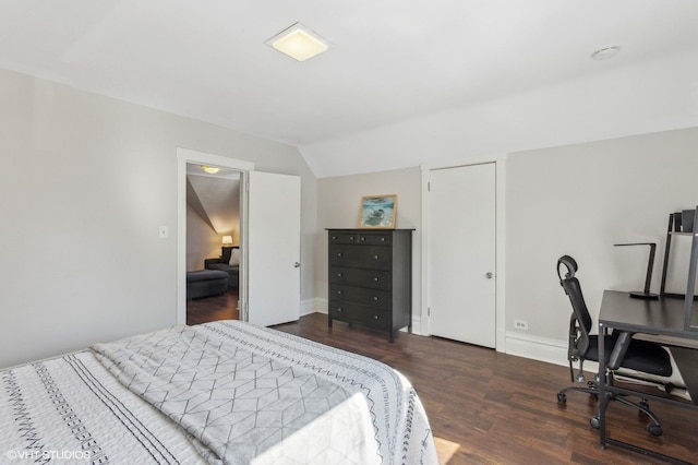 bedroom with vaulted ceiling, baseboards, and wood finished floors