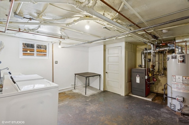 below grade area with a heating unit, washer and clothes dryer, and gas water heater