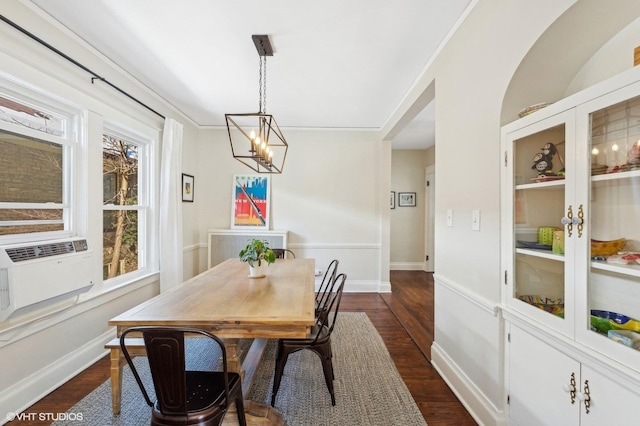 dining room with baseboards, dark wood finished floors, crown molding, cooling unit, and a chandelier