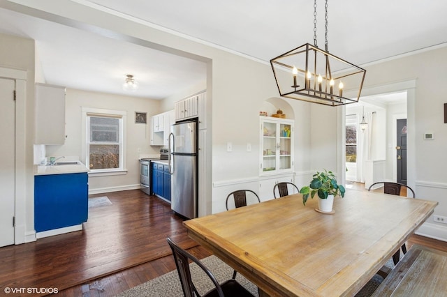 dining space featuring dark wood-style floors and ornamental molding