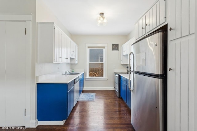 kitchen featuring blue cabinetry, appliances with stainless steel finishes, light countertops, and a sink