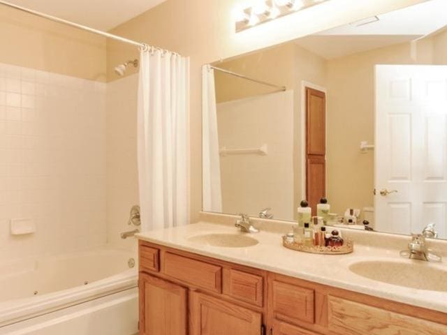 bathroom featuring vanity and shower / bath combination with curtain