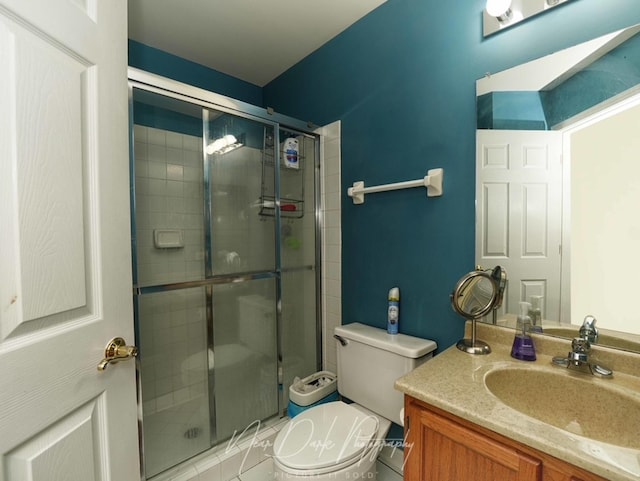 bathroom with vanity, a shower with shower door, and toilet