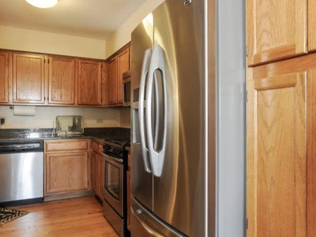 kitchen with stainless steel appliances and light hardwood / wood-style floors