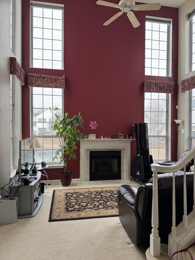 living room featuring carpet flooring, a tile fireplace, and a high ceiling