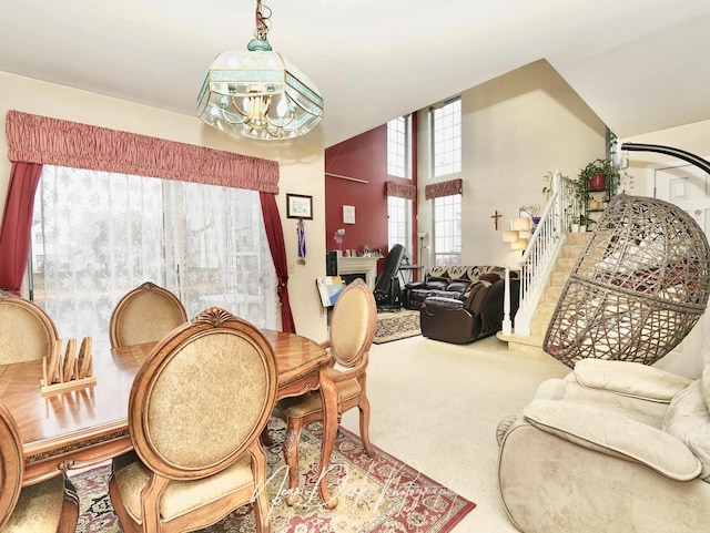 dining space featuring carpet floors and high vaulted ceiling