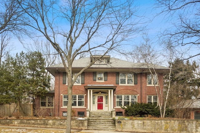 view of front facade featuring fence and brick siding