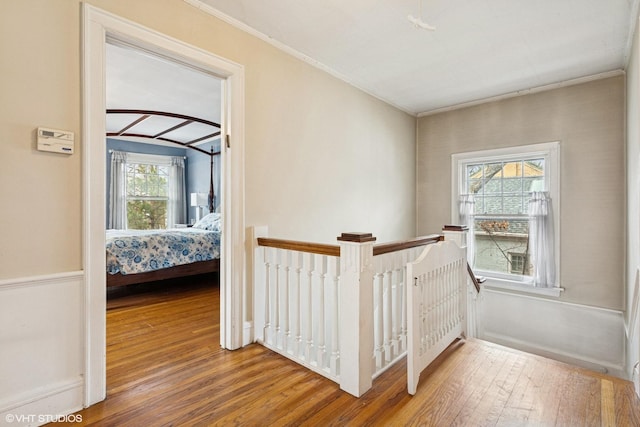 hall featuring crown molding, hardwood / wood-style floors, and an upstairs landing