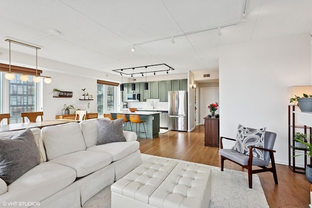 living room featuring visible vents, dark wood finished floors, and track lighting