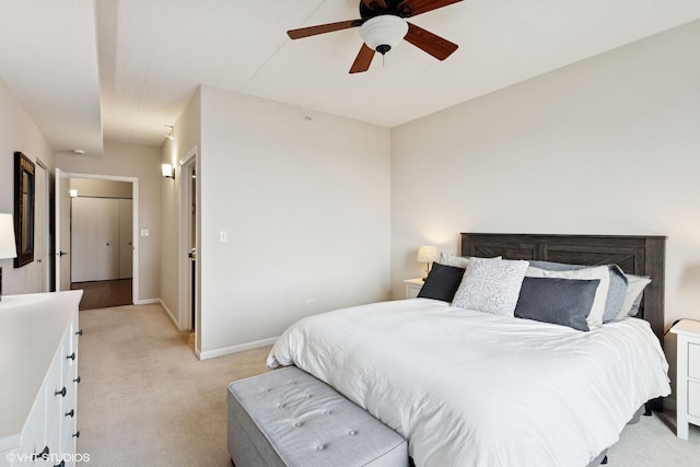 bedroom featuring light carpet, a ceiling fan, and baseboards