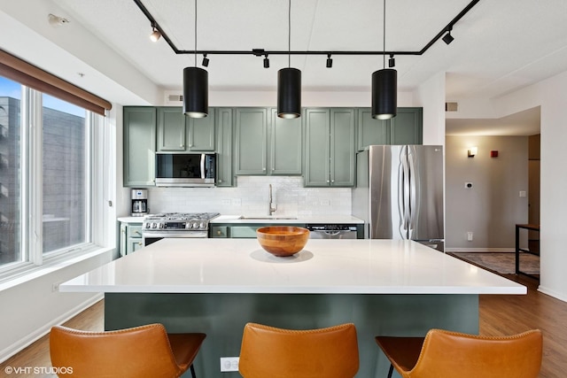 kitchen featuring green cabinets, plenty of natural light, and stainless steel appliances