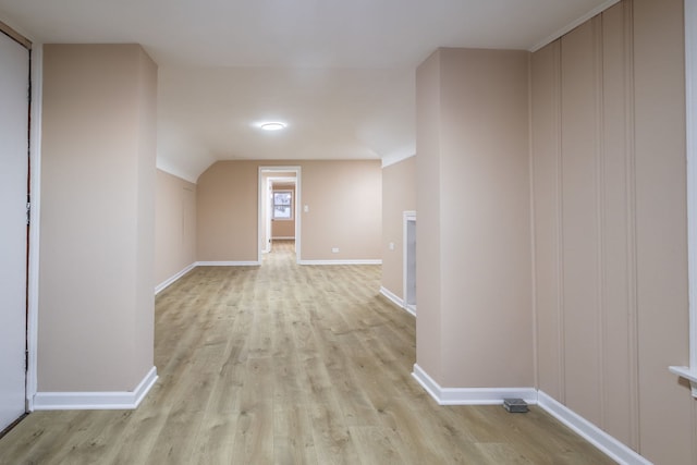 hall featuring light wood-type flooring and lofted ceiling