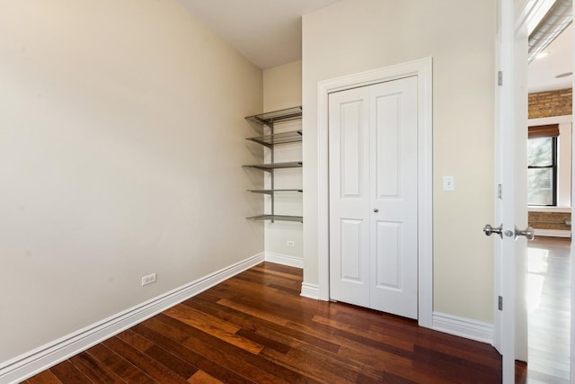 unfurnished bedroom with dark hardwood / wood-style flooring and a closet