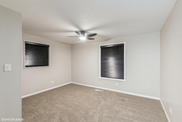 empty room featuring ceiling fan and carpet