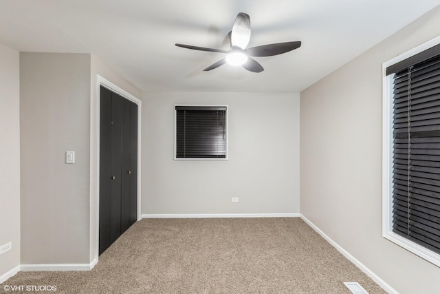 unfurnished room with ceiling fan and carpet flooring