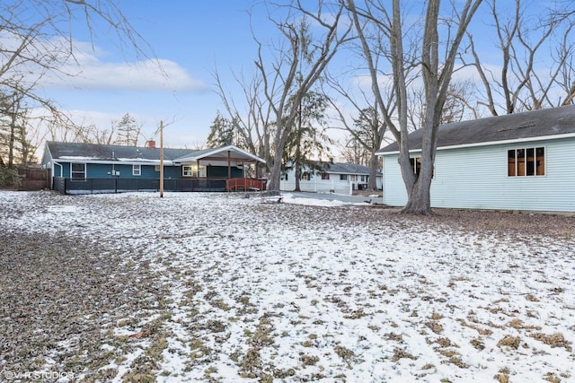 view of snow covered back of property