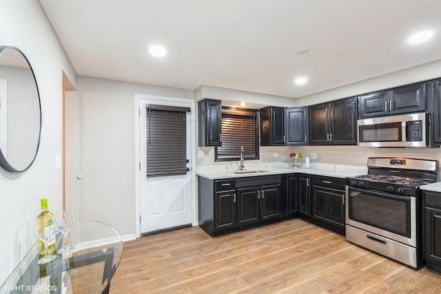 kitchen with sink, light hardwood / wood-style flooring, and appliances with stainless steel finishes