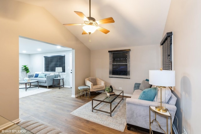 living room with hardwood / wood-style floors, vaulted ceiling, and ceiling fan